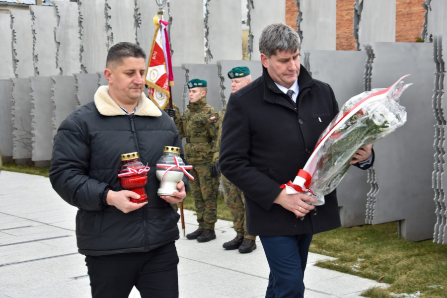 T. Choroszewski (od lewej) i P. Rusiecki składają wiązankę kwiatów przy murze pamięci Ofiar Obławy Augustowskiej 